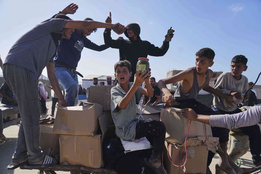 FILE - Palestinians carry boxes containing food and humanitarian aid packages delivered by the Gaza Humanitarian Foundation