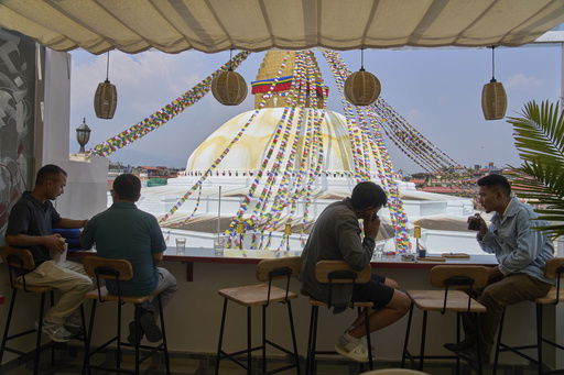 People drink coffee overlooking Boudhanath Stupa at Himalayan Java cafe in Kathmandu