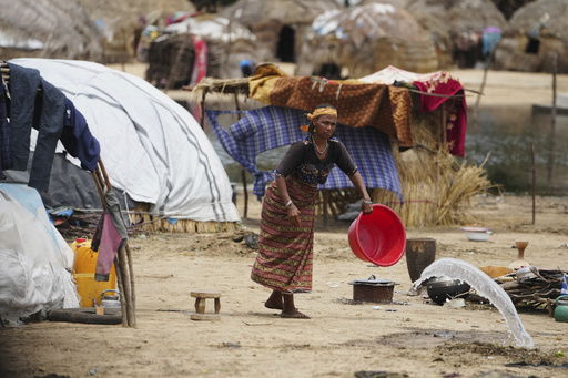 A Fulani woman empties water from a bowl outside her house in Konduga
