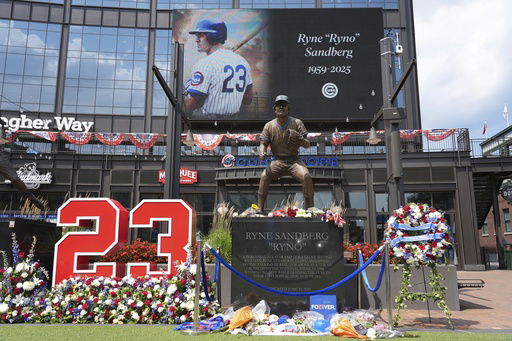 Fans leave flowers and other items at a makeshift memorial in front of the statue of Chicago Cubs' Hall of Fame second baseman Ryne Sandberg