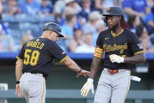 Pittsburgh Pirates' Oneil Cruz celebrates with third base coach Mike Rabelo (58) after hitting a solo home run during the fourth inning of a baseball game against the Kansas City Royals