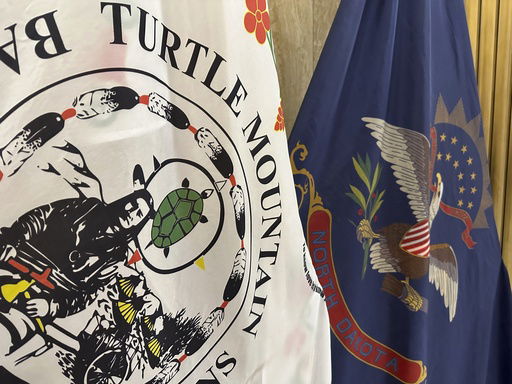 FILE - Flags for the Turtle Mountain Band of Chippewa Indians and the state of North Dakota stand in Memorial Hall of the state Capitol in Bismarck