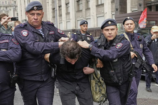Police detain an activist during a picket against internet limitations in front of The State Duma