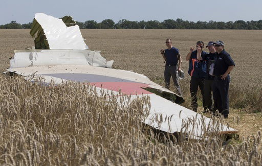 FILE - Australian and Dutch investigators examine a piece of the Malaysia Airlines Flight 17 plane
