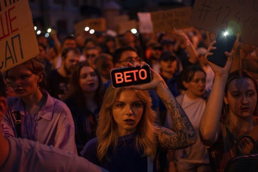 A woman holds a phone with a sign reads