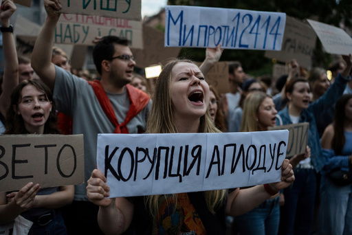 A woman chants while holding a banner that reads