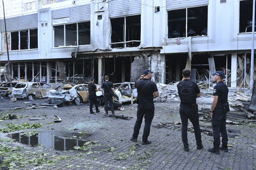 Police officers inspect damaged cars at a residential area following Russia's drone attack in Odesa