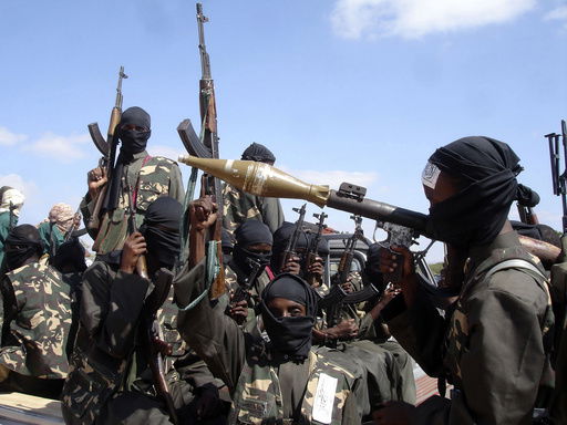 FILE - Armed al-Shabab fighters ride on pickup trucks as they prepare to travel into the city