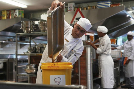 A culinary student pours a cooked soup into a container