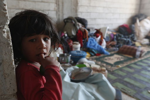 A displaced Bedouin girl stands inside a shelter after her family fled their home due to clashes between Bedouin clans and Druze militias