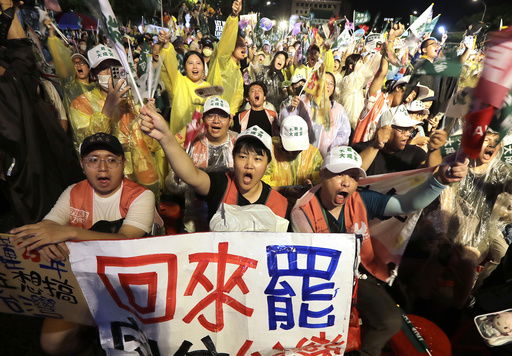 People shoot and hold a slogan reading ''Come Back to Recall'' during a campaign rally to promote recall vote targeting 24 Nationalist Party (KMT) lawmakers in Taipei