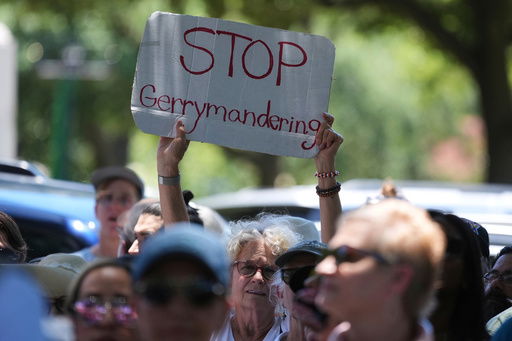 A woman holds a sign during a rally to protest against redistricting hearings at the Texas Capitol