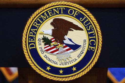 FILE - The U.S. Department of Justice logo is seen on a podium before a press conference with Attorney General Pam Bondi