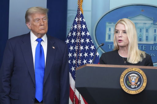 Attorney General Pam Bondi speaks to reporters as President Donald Trump listens