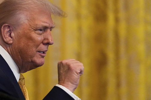 President Donald Trump raises his fist after speaking during a reception for Republican members of Congress in the East Room of the White House
