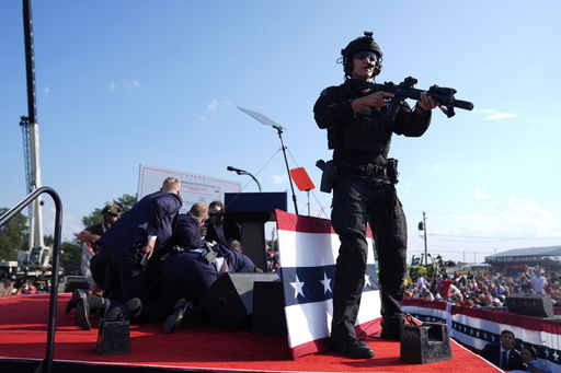 FILE - Republican presidential candidate former President Donald Trump is covered by U.S. Secret Service agents at a campaign rally