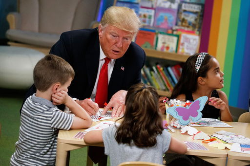 FILE - President Donald Trump colors during a visit with a group of children at the Nationwide Children's Hospital