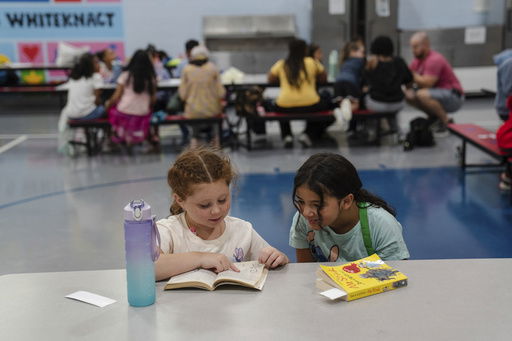 Girls read an Amelia Bedelia book during the East Providence Boys and Girls Club Summer Camp at Emma G. Whiteknact Elementary School on Thursday