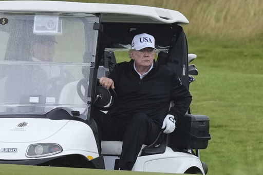 President Donald Trump steers a golf cart at the Trump Turnberry golf course in Turnberry