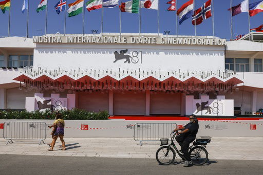 FILE - Festival goers pass the red carpet of the 81st edition of the Venice Film Festival in Venice