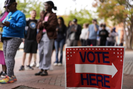 FILE - People stand in line during the last day of early voting