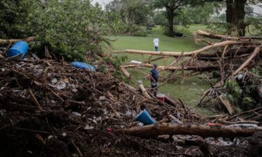 Two men search for survivors after flash flooding on the bank Guadalupe River on July 5 in Center Point