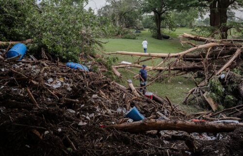 Two men search for survivors after flash flooding on the bank Guadalupe River on July 5 in Center Point