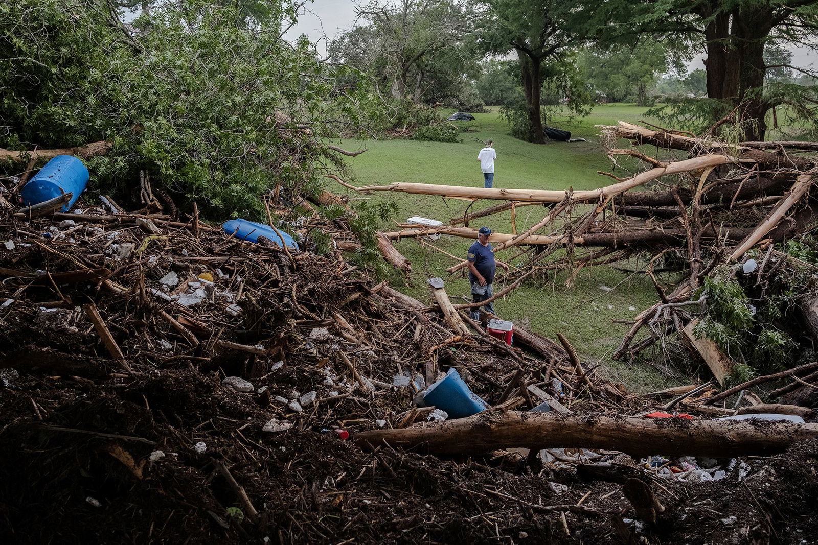 <i>Jim Vondruska/Getty Images via CNN Newsource</i><br/>Two men search for survivors after flash flooding on the bank Guadalupe River on July 5 in Center Point