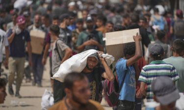 People carry relief supplies from a Gaza Humanitarian Foundation (GHF) aid distribution centre in the central Gaza Strip on June 8.