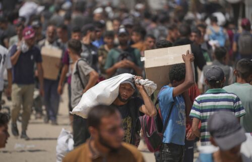 People carry relief supplies from a Gaza Humanitarian Foundation (GHF) aid distribution centre in the central Gaza Strip on June 8.