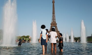 Parisians and tourists cool off at the Trocadero fountain in Paris