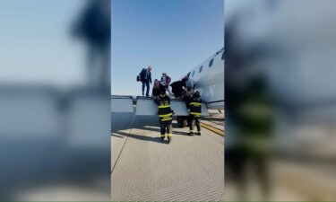 Passengers climb off the the wing of United Express flight 4423 after it made an emergency landing in St. Louis.