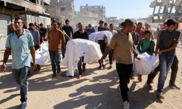 Mourners carry the bodies of Palestinians who were killed in an overnight Israeli strike