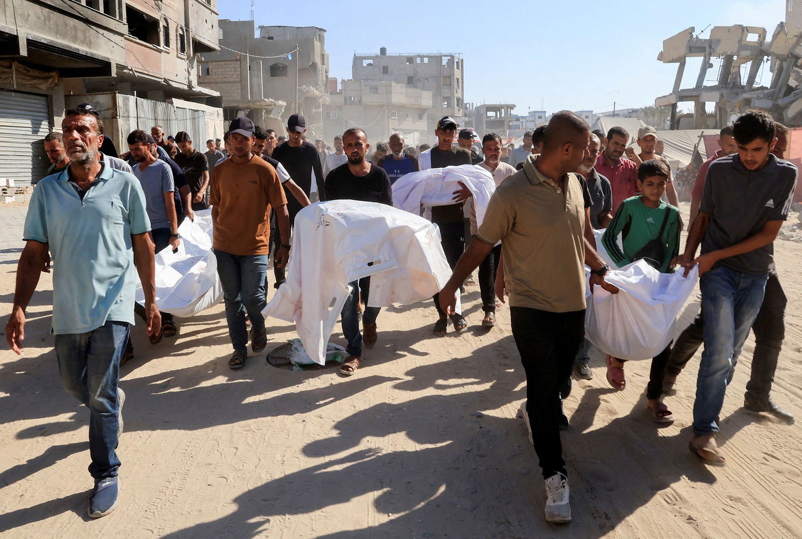 <i>Hatem Khaled/Reuters via CNN Newsource</i><br/>Mourners carry the bodies of Palestinians who were killed in an overnight Israeli strike