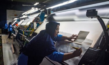 A worker inspects fabric for export before the dyeing process at the Trisula Textile Industries factory in Cimahi