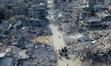 People make their way past the rubble of houses in Rafah