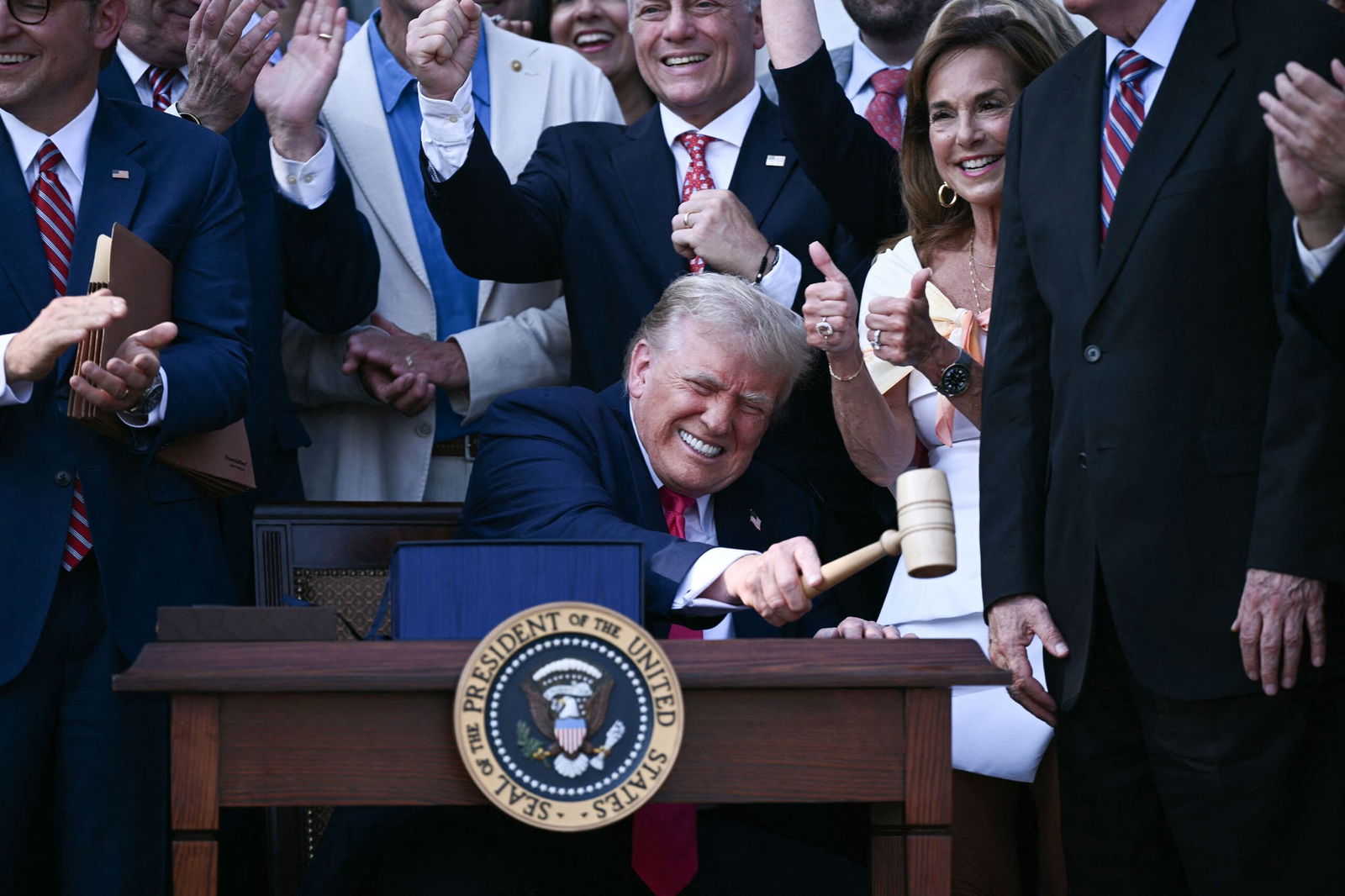 <i>Brendan Smialowski/AFP/Getty Images via CNN Newsource</i><br/>President Donald Trump bangs a gavel after signing a sweeping tax and spending cuts package he called his 