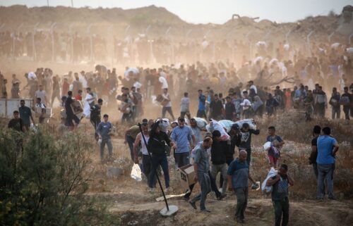 People carry relief supplies from the Gaza Humanitarian Foundation (GHF) on June 8