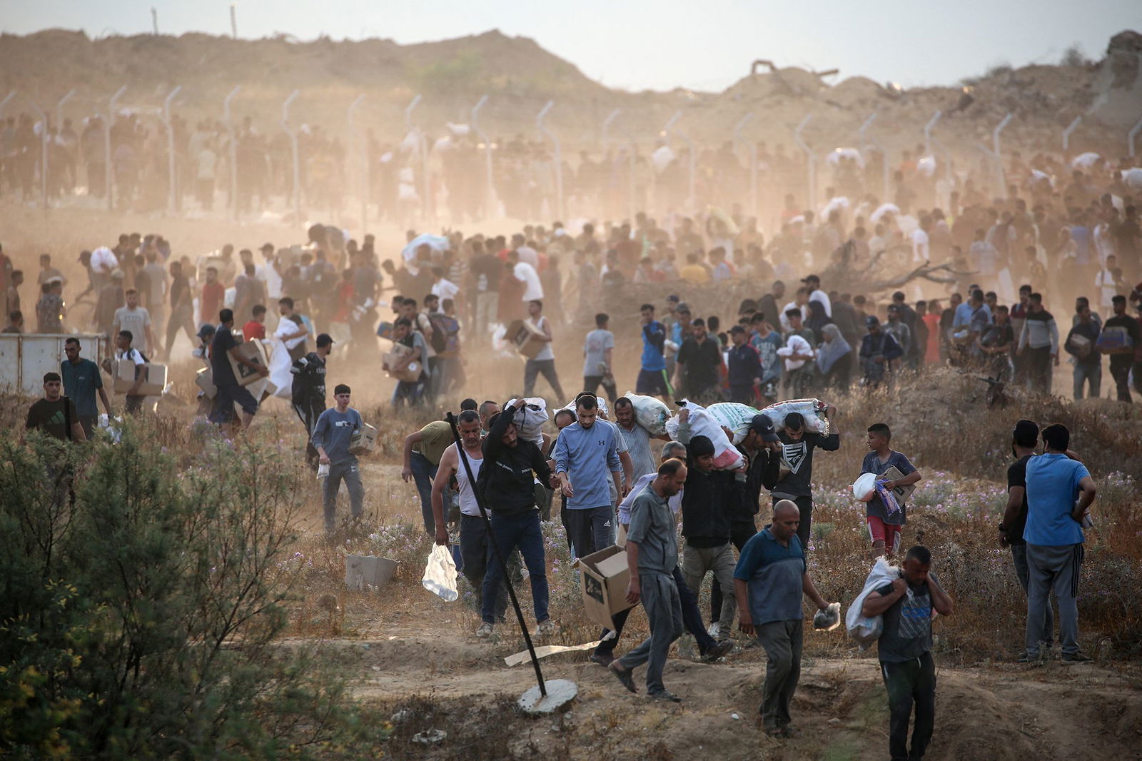 <i>Eyad Baba/AFP/Getty Images via CNN Newsource</i><br/>People carry relief supplies from the Gaza Humanitarian Foundation (GHF) on June 8