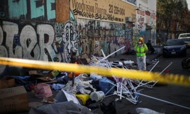 Stockton Police officers watch as inhabitants of a homeless encampment on an island on White Slough move their possessions onto a levee along Trinity Parkway near McAuliffe Road in north Stockton