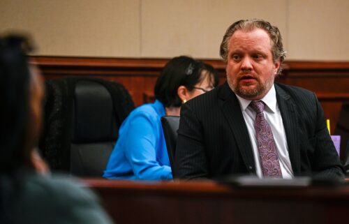 James Craig talks with his family from his seat before opening arguments in his murder trial at the Arapahoe District Court on July 15 in Centennial