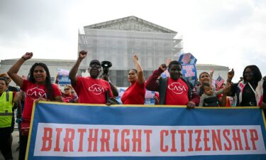People hold a banner as they participate in a protest outside the US Supreme Court over President Donald Trump's move to end birthright citizenship as the court hears arguments over the order in Washington