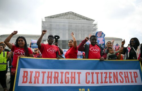 People hold a banner as they participate in a protest outside the US Supreme Court over President Donald Trump's move to end birthright citizenship as the court hears arguments over the order in Washington
