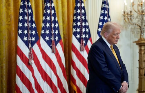 US President Donald Trump bows his head in prayer during a reception with Republican members of Congress in the East Room of the White House in Washington