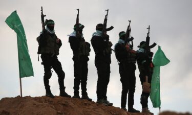 Palestinian Hamas militants gather at the site of the handing over of the bodies of four Israeli hostages in Khan Younis in the southern Gaza on February 20.
