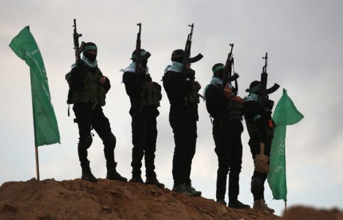 Palestinian Hamas militants gather at the site of the handing over of the bodies of four Israeli hostages in Khan Younis in the southern Gaza on February 20.