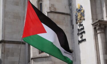 A Palestinian flag is waved outside The Royal Courts of Justice in central London on July 30.