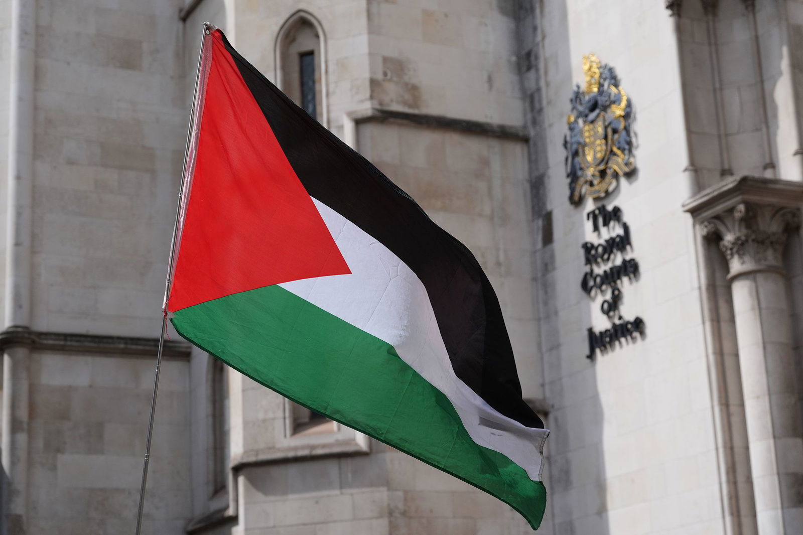 <i>Jonathan Brady/PA Images/Getty Images via CNN Newsource</i><br/>A Palestinian flag is waved outside The Royal Courts of Justice in central London on July 30.