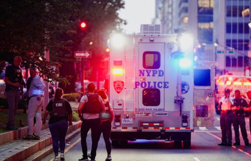 FBI agents investigate near a New York Police Department (NYPD) response vehicle near the scene of a reported shooter situation in Manhattan.