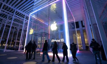 People walk by the Apple Store on Fifth Avenue during sunset in New York City. Apple reported strong iPhone sales and rebound in revenue from China.